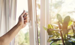 hand open white plastic pvc window at home